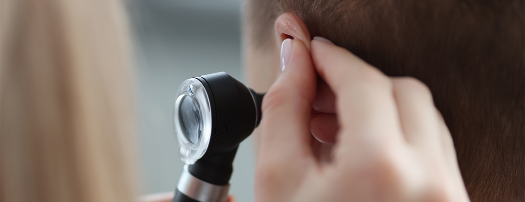 Image of hearing professional tool being used to examine the ear of a patient